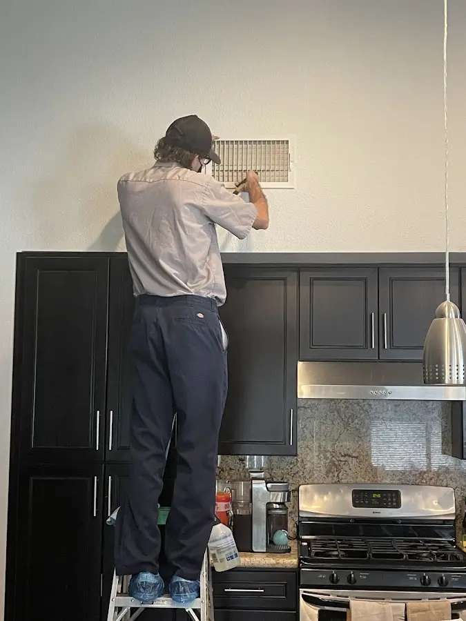 Technician inspecting an air vent during HVAC service in Bellwood